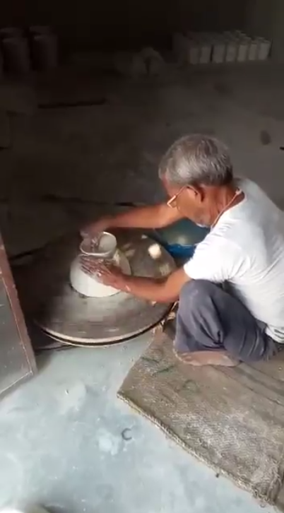 Potier façonnant une pièce sur son tour dans l'atelier