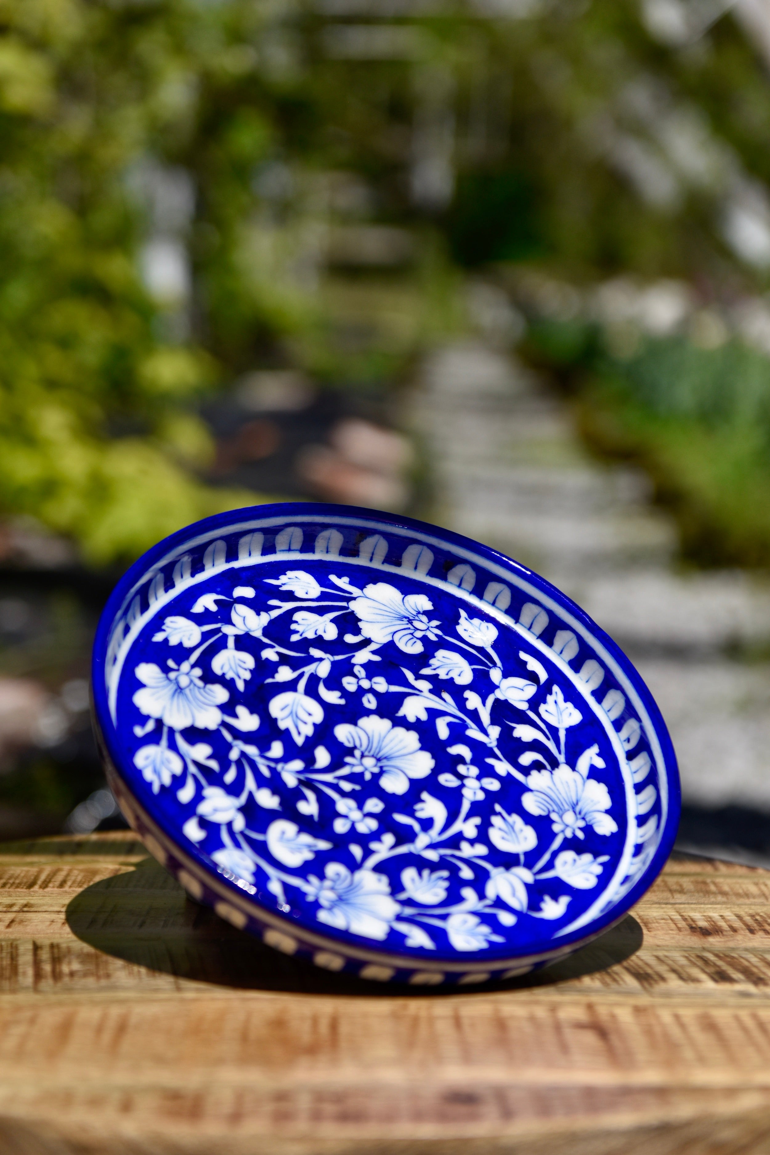 Assiette ronde bleu foncé aux motifs blancs et bleus