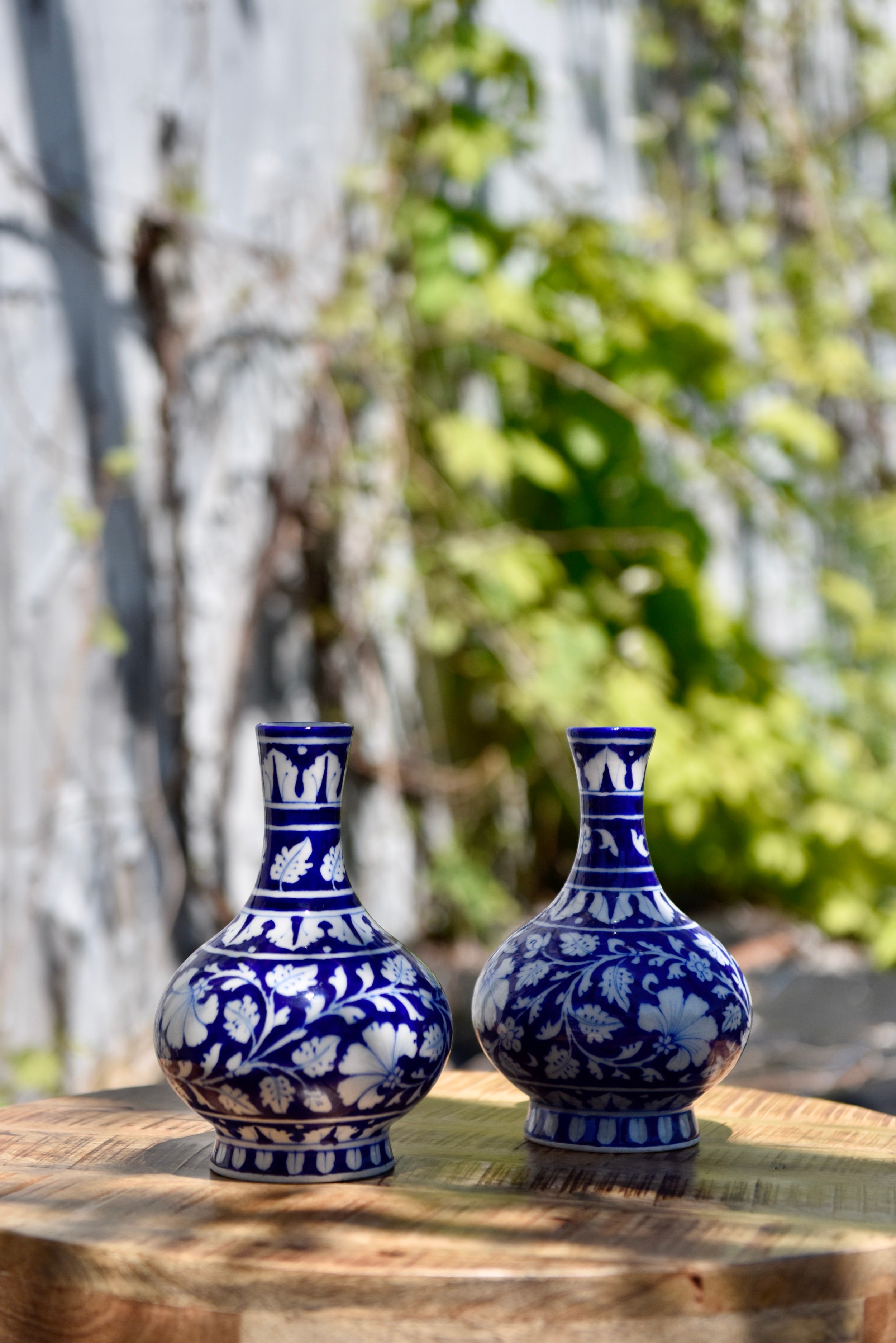 Deux petits vases bleu foncé aux motifs floraux blancs