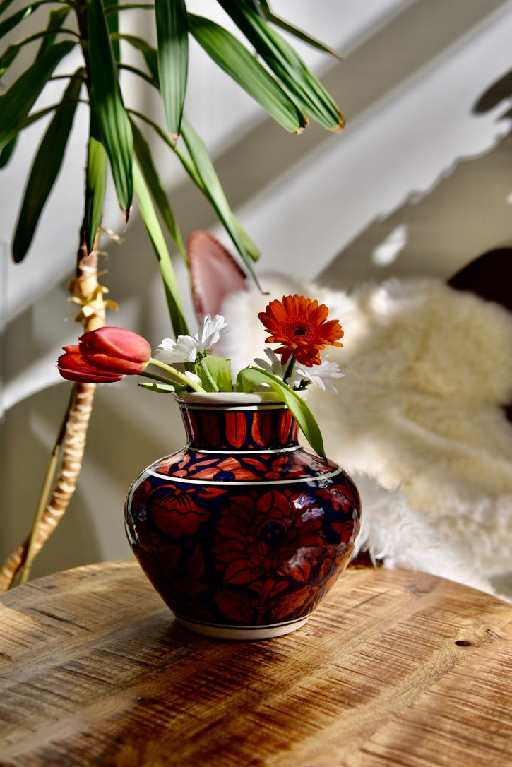 Vase rond orné de fleurs rouges et bleu foncé