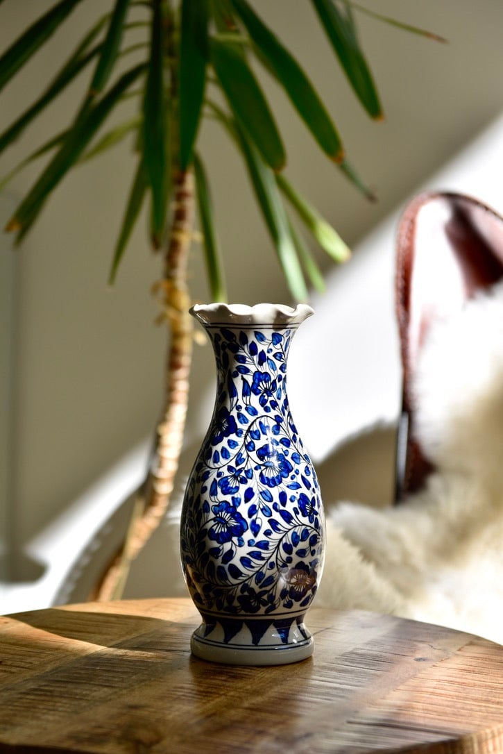Vase blanc à ouverture ondulée et fleurs bleues