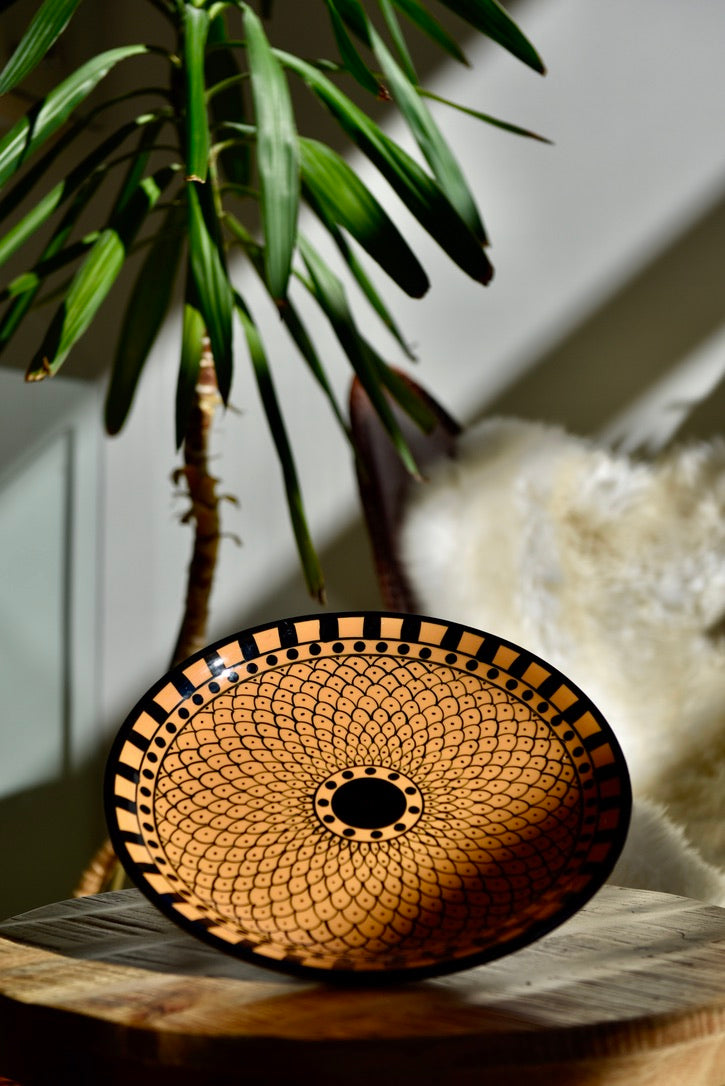 Assiette orange ornée de motifs noirs